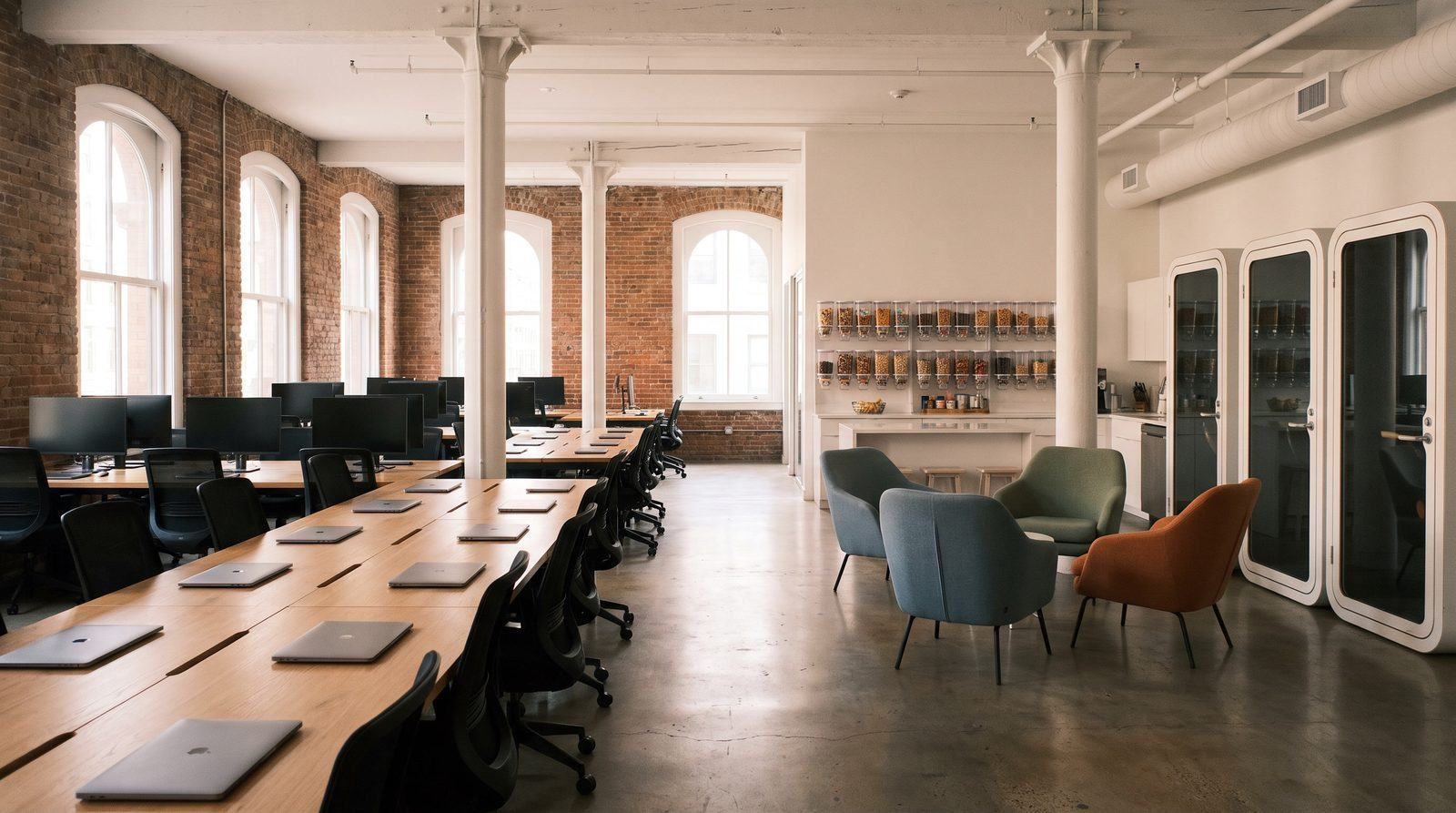 A clean loft-style office with long shared desks the morning after a nightly clean